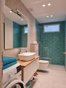 伯德古拉Beachfront Comfort Apartments SINAJKO的浴室设有水槽、卫生间和绿色瓷砖。