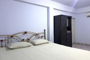 特尔纳特岛OYO 92892 Aini Homestay的一间卧室配有一张床和一个黑色橱柜