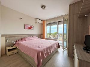 卡瓦尔纳Golf Villa Ariel的卧室配有粉红色的床和窗户。