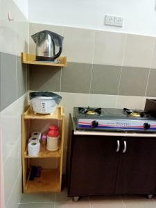 瓜拉丁加奴Homestay Camelia Kuala Terengganu Houses 3 Room 2 Bathroom - Near Batu Buruk Beach , Drawbridge, Pasar Payang, KTCC Mall & Hospital HSNZ的厨房配有炉灶和台面