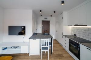 瓦尔米亚地区利兹巴克Apartament Alpaka 2的一间厨房,配有白色橱柜和厨房岛
