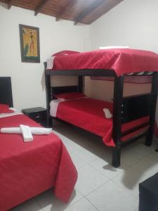麦德林HOGAR DEL VIAJERO的客房设有2张双层床和红色床单