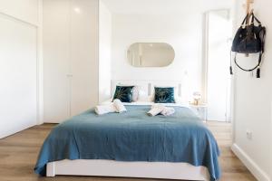 波尔图Guest H4U - Porto Bonfim Heroismo的一间卧室配有一张带蓝色棉被的床