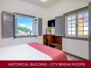 奥比多斯Casa Senhoras Rainhas AL - Obidos - by Unlock Hotels的一间卧室设有一张床和一个窗口