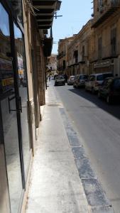 利卡塔Benvenuti al Sud B&B的一条空的街道,汽车停在大楼的一侧