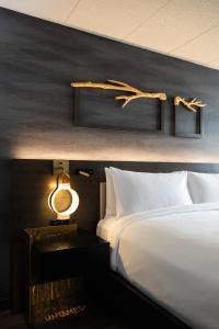 诺斯布鲁克芝加哥北岸万丽酒店的一间卧室配有一张床和一张带台灯的桌子