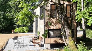 Saint-LégerTiny Gaumaise - Tiny house à Saint-leger的一座带椅子和桌椅的建筑