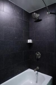 诺斯布鲁克芝加哥北岸万丽酒店的黑色瓷砖浴室设有水槽和淋浴