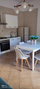 索伦托Il Tulipano的厨房配有白色的桌椅