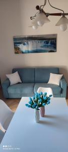 索伦托Il Tulipano的客厅配有白色桌子和蓝色沙发