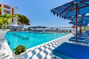 圣埃乌拉利亚Hotel Mongibello Ibiza的一个带蓝色椅子和遮阳伞的游泳池