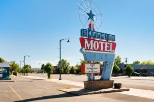 博兹曼Sapphire Motel Midtown Bozeman的停车场中央的汽车旅馆标志