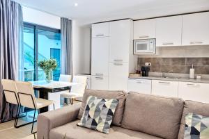 圣玛丽亚Lc Apartments - Sunshine的厨房以及带沙发和桌子的客厅。