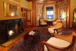 克尼斯纳猎鹰视角庄园酒店的客厅设有壁炉、椅子和桌子