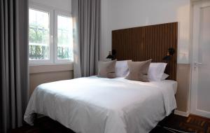 利马Fausto的卧室配有一张白色大床和两个窗户