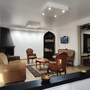 基多Hotel Muros Quito的带沙发和椅子的客厅以及电视