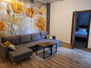 卡托维兹Aparthotel Krzywa的客厅配有沙发和桌子