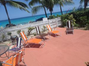 圣詹姆斯安娜贝尔酒店的一组椅子坐在海滩附近的庭院里