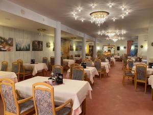 布尔格-罗伊兰德Hotel Altitude的餐厅配有白色的桌椅和吊灯