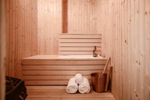 瓦斯泰纳瓦斯泰纳Spa酒店的一间桑拿浴室,配有两条毛巾、一个浴缸和一个桶
