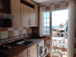 莫哈卡尔Apartamento Delfín的厨房设有水槽和窗户旁的洗碗机