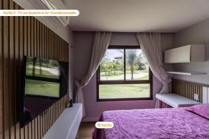 卡姆布库Térreo com churrasqueira no VG Sun por Tactu的一间卧室设有紫色的床和窗户