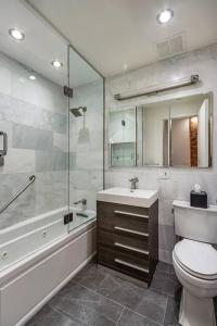 纽约Luxurious 2 Bedroom Loft Entire Apartment的浴室配有卫生间、盥洗盆和淋浴。
