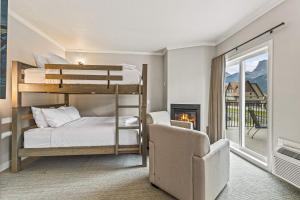 坎莫尔Northwinds Hotel Canmore的一间卧室设有两张双层床和一个壁炉