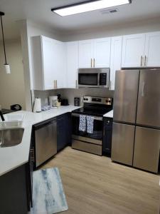 夏洛特South Charlotte’s Cozy & Modern的厨房配有不锈钢用具和白色橱柜