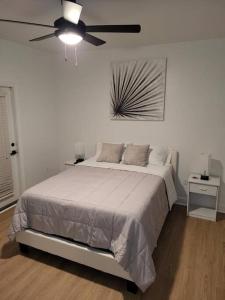 夏洛特South Charlotte’s Cozy & Modern的白色卧室配有床和吊扇