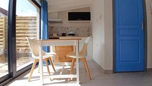 Margny-lès-CompiègneMaisonnette entière et privée, 600m de la gare的厨房里设有一张桌子和椅子,还有一扇蓝色的门