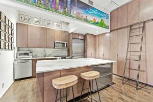 纽约Furnished and Meticulously Renovated 3-bedroom, 2-bathroom Loft的厨房配有柜台和2把凳子