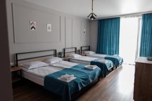 卡兹贝吉ALOFT的配有蓝色窗帘的客房内的两张床