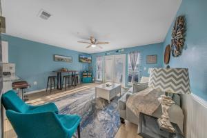 彭萨科拉Grand Caribbean in Perdido Key 111E by Vacation Homes Collection的客厅拥有蓝色的墙壁,配有沙发和椅子
