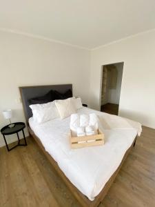 亚历山德拉Springvale Apartment的一张白色大床,上面有木制托盘