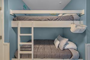 彭萨科拉Grand Caribbean in Perdido Key 111E by Vacation Homes Collection的蓝色客房 - 带两张双层床和梯子