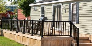 滨湖尼亚加拉Vine Ridge Resort - Cottages的一只狗坐在带围栏的甲板上