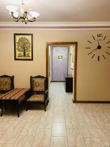 埃里温Eco的一间墙上挂有时钟的房间和两把椅子