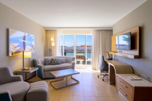 克拉伦代克Courtyard by Marriott Bonaire Dive Resort的一间客厅,客厅配有沙发和电视,位于酒店的房间