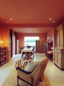 KortenakenRoos 14, sfeervol vakantieverblijf in hartje Hageland的客厅设有橙色墙壁和桌椅