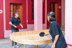 瓦哈卡市Viajero Oaxaca Hostel的两个人在乒乓球桌前打乒乓球