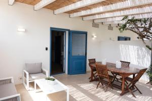 圣维托罗卡波Villa Blumarine sul mare的一间带桌椅和蓝色门的用餐室