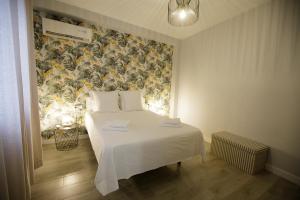 科尔多瓦Atico Casa Lola的卧室配有白色床和花卉壁纸