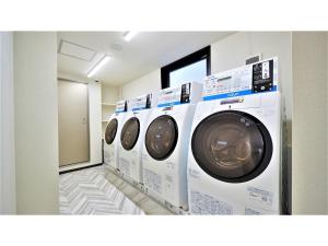 那霸Y's Inn Naha Oroku Ekimae - Vacation STAY 25852v的洗衣房里的一排白色洗衣机