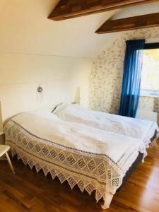 SvenshögenLovely holiday house by a beautiful lake!的卧室配有白色床和蓝色窗帘