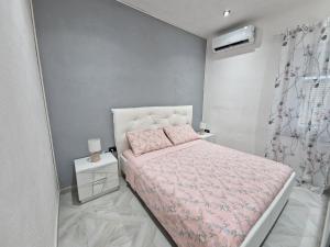 马达莱纳La Maddalena Holiday Home的一间小卧室,配有粉红色的床和粉色毯子