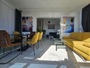 诺瓦利娅The Luxury Apartments - Villa Havana的客厅配有黄色的沙发和桌子