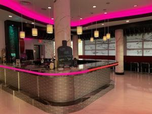 代托纳海滩The Streamline Hotel - Daytona Beach的餐厅内的酒吧拥有粉红色的灯光