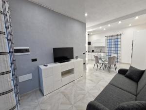 马达莱纳La Maddalena Holiday Home的客厅配有电视、沙发和桌子
