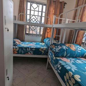 阿鲁沙Mufasa city Hostel and Apartments的客房设有两张双层床和一扇窗户。